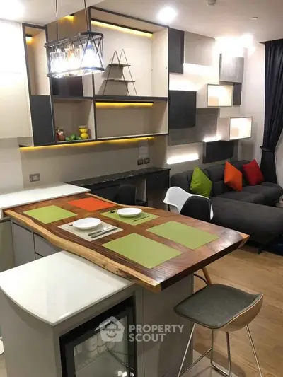 Modern kitchen with stylish open layout and cozy living area, featuring contemporary lighting and vibrant decor.