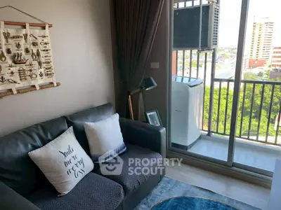 Cozy living room with balcony view and washing machine, perfect for urban living.
