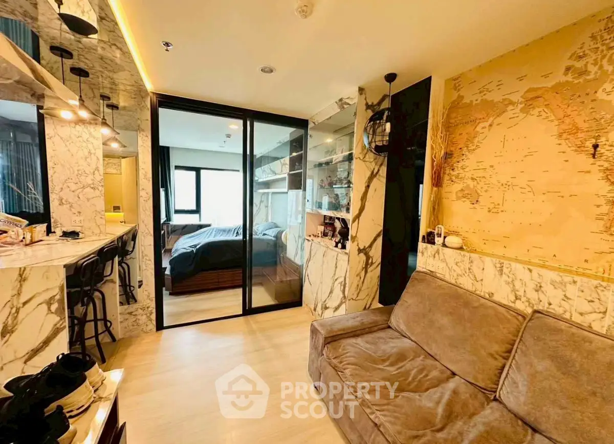 Luxurious living room with marble accents and cozy sofa, leading to a stylish bedroom.