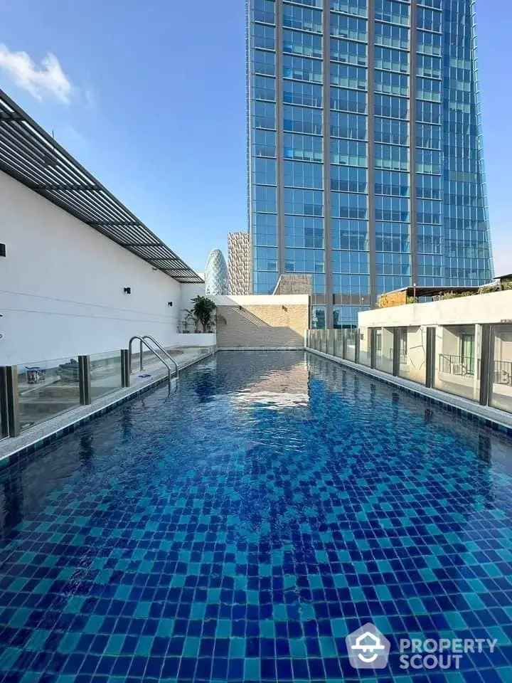 Luxurious rooftop pool with stunning city skyline views, offering a serene escape amidst the bustling urban environment.