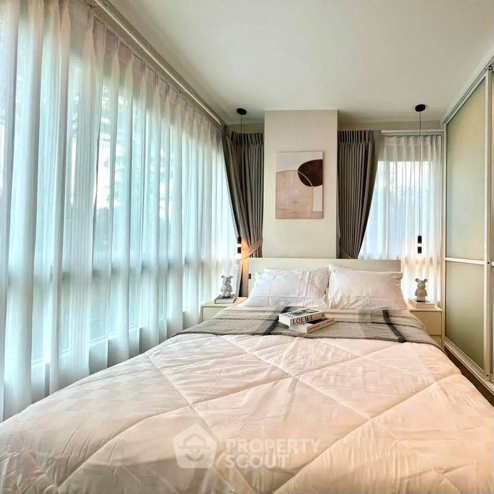 Bright and cozy bedroom with large windows and modern decor, perfect for relaxation.