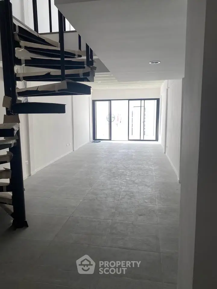 Spacious modern interior with spiral staircase and large windows, perfect for open living concepts.