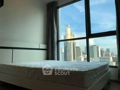 Spacious bedroom with city view and large window, perfect for urban living.