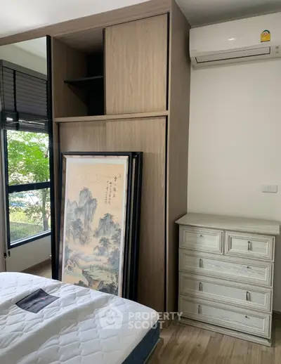 Cozy bedroom with wooden wardrobe and air conditioning, perfect for comfort and style.