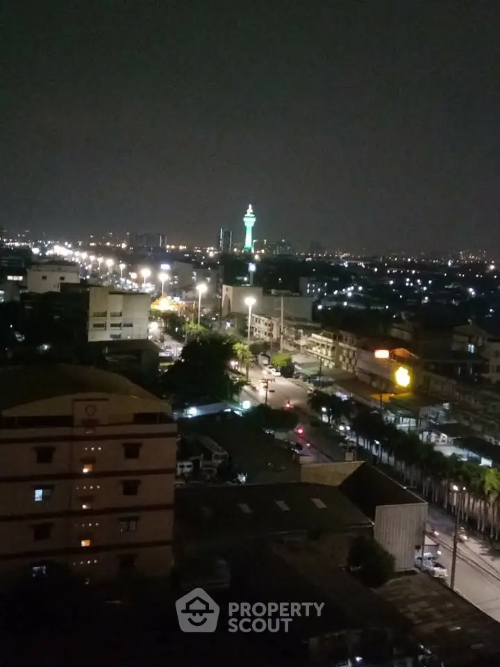 Stunning night cityscape view with illuminated tower and bustling streets.