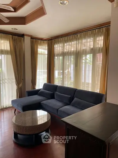Spacious living room with elegant curtains and modern sectional sofa, perfect for relaxation and entertaining.