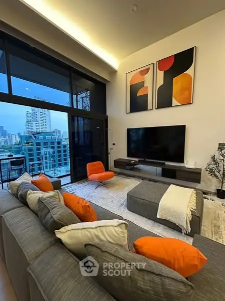 Modern living room with city view, stylish decor, and large TV setup.