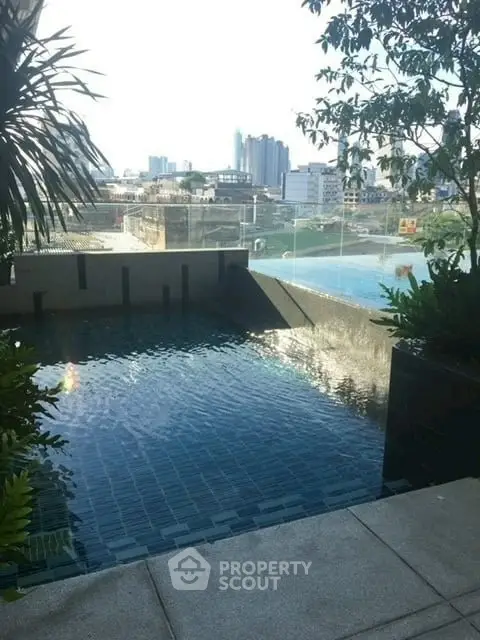 Luxurious rooftop pool with stunning city view and lush greenery