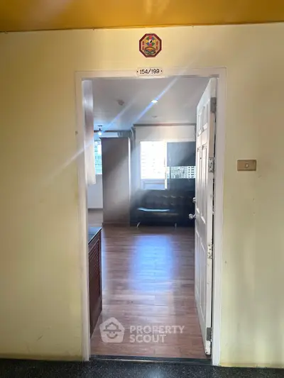 Bright entrance to modern apartment with wooden flooring and city view.