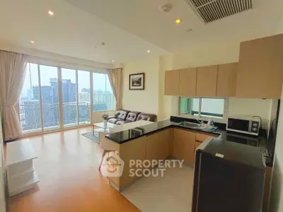 Modern open-layout living room with kitchen, featuring large windows and city view.