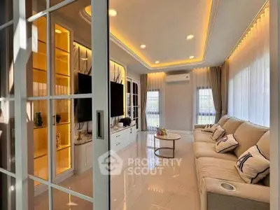 Luxurious living room with elegant lighting and modern decor, featuring a spacious sofa and large TV.