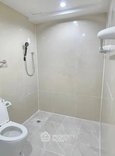 Modern bathroom with sleek tiles and shower, ideal for contemporary living.