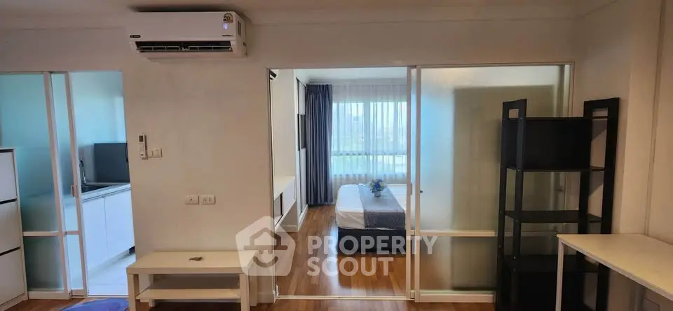 Modern apartment interior with bedroom and living area, featuring sleek design and natural light.