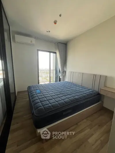 Modern bedroom with large window and stylish furnishings