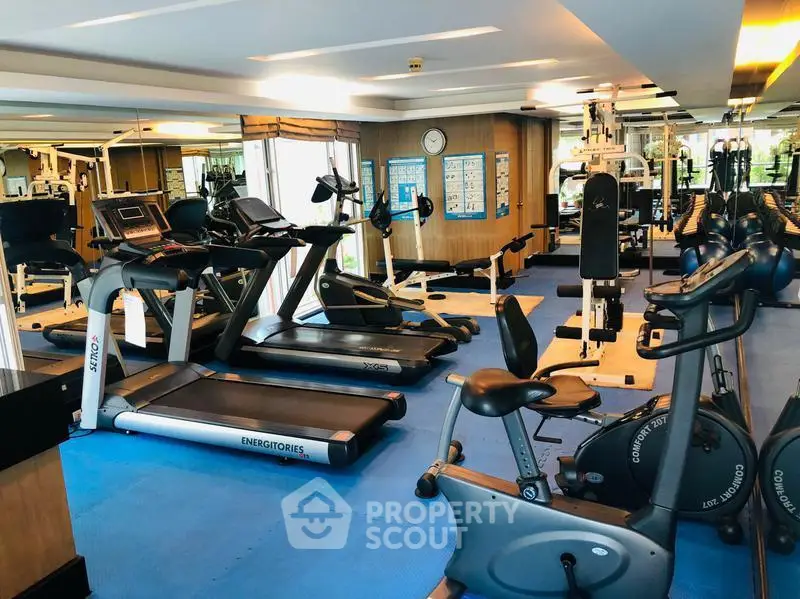 Spacious modern gym with state-of-the-art fitness equipment and mirrored walls.