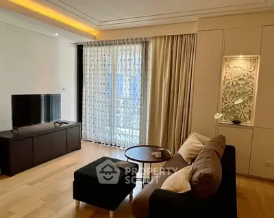 Modern living room with elegant decor and natural light, featuring a cozy sofa and stylish TV unit.