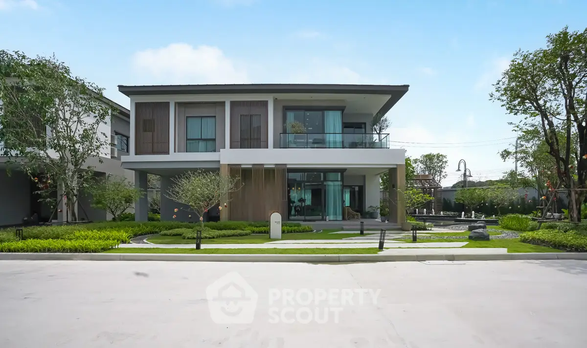 Modern two-story house with landscaped garden and spacious balcony in a serene neighborhood.