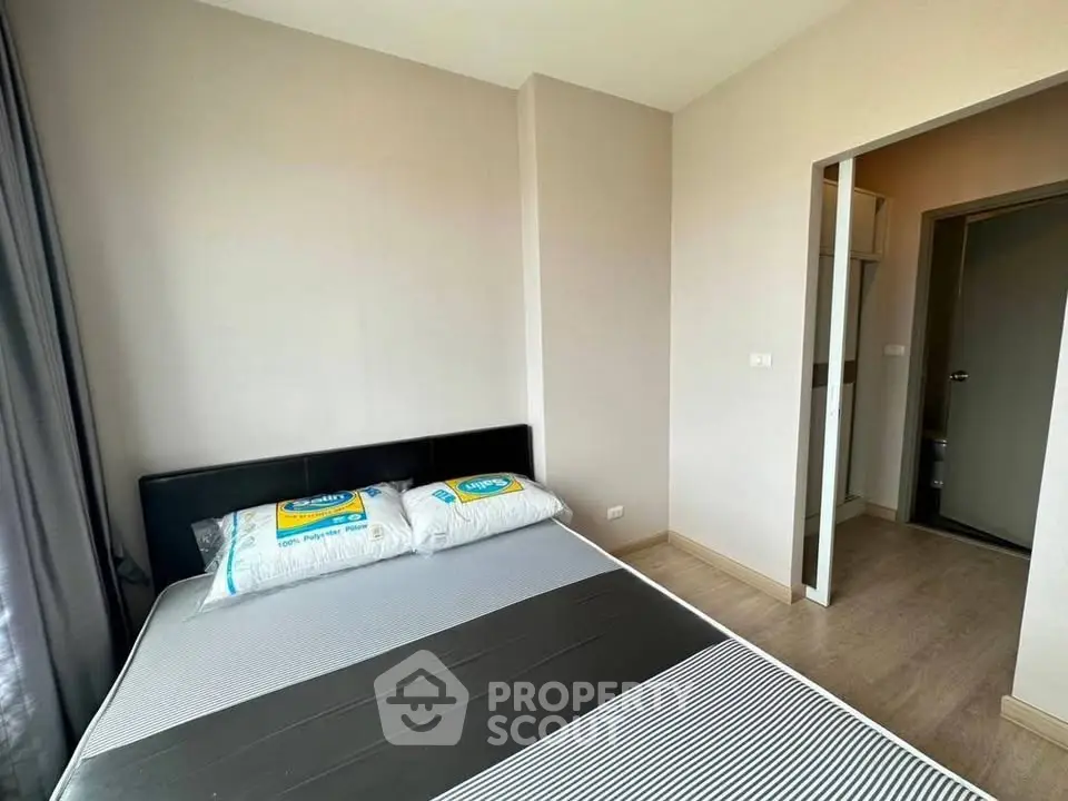 Modern bedroom with sleek design and ample natural light, featuring a comfortable bed and minimalist decor.