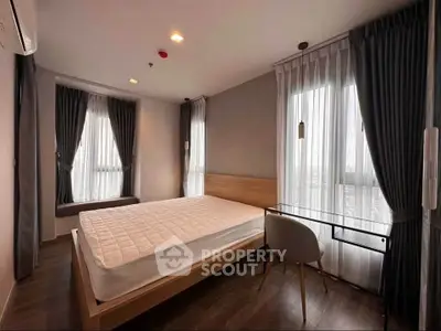 Modern bedroom with large windows and stylish decor in a contemporary apartment.