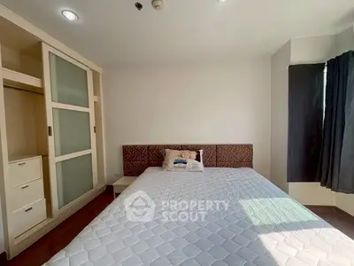 Bright and cozy bedroom with modern wardrobe and ample natural light.
