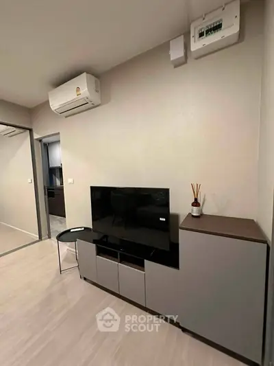 Modern living room with sleek TV stand and air conditioning in a stylish apartment.