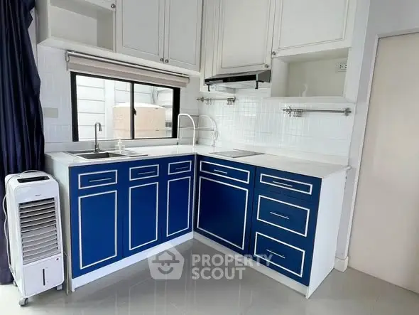 Modern kitchen with blue cabinets and sleek white countertops