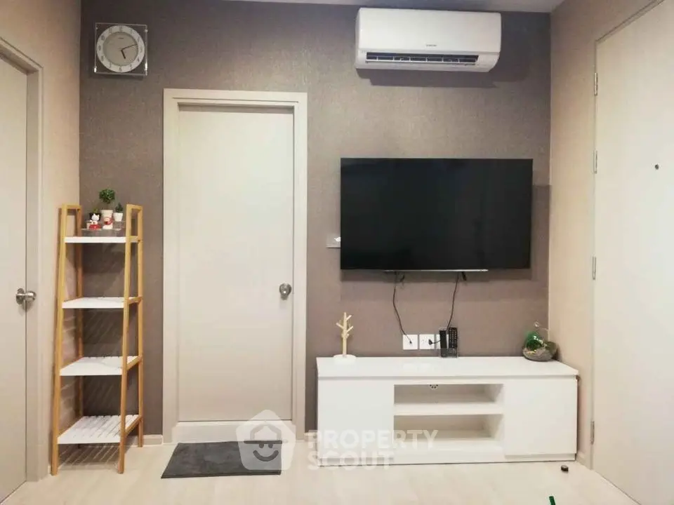 Modern living room with wall-mounted TV and air conditioning unit, featuring minimalist decor and shelving.