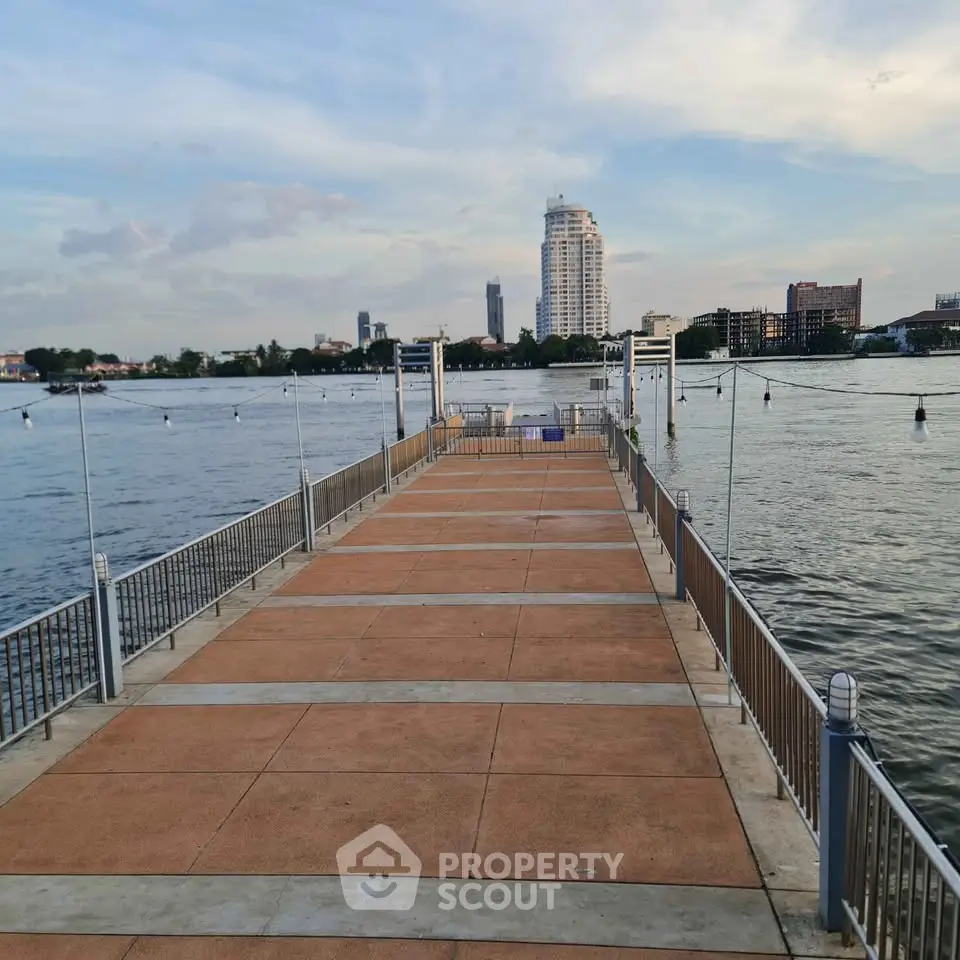 Scenic riverside view with modern buildings and a spacious dock, perfect for waterfront living.