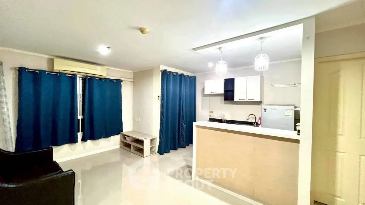 Modern open-layout living room with stylish kitchen and blue curtains