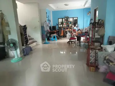 Spacious living room with tiled flooring and modern decor, ideal for family gatherings.
