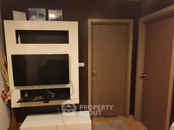 Modern living room with wall-mounted TV and wooden doors