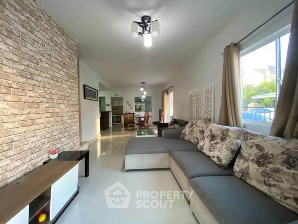 Spacious living room with modern decor and large windows offering natural light.