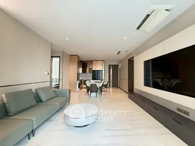 Spacious modern living room with sleek furniture and open kitchen layout