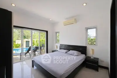 Spacious bedroom with pool view and modern furnishings