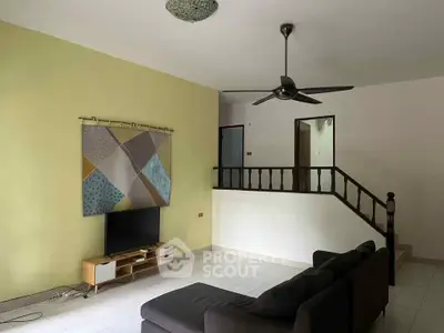 Spacious living room with modern decor and ceiling fan, perfect for relaxation.