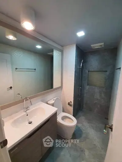 Modern bathroom with sleek fixtures and spacious shower area in contemporary home.