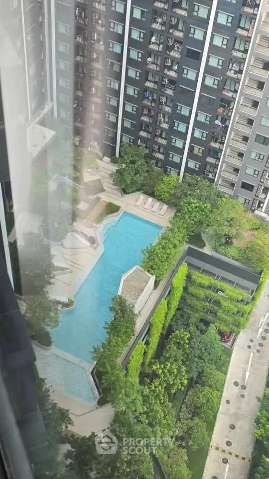 Stunning aerial view of modern apartment complex with pool and lush greenery.