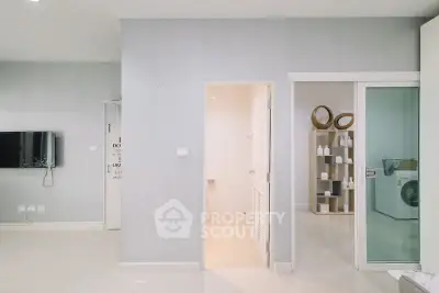 Modern interior with sleek design featuring a wall-mounted TV and stylish shelving.