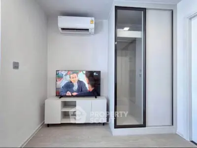 Modern living room with sleek TV setup and air conditioning in a stylish apartment.