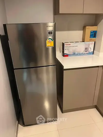 Modern kitchen with sleek stainless steel fridge and contemporary cabinetry.