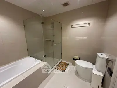 Modern bathroom with glass shower and bathtub in luxury apartment