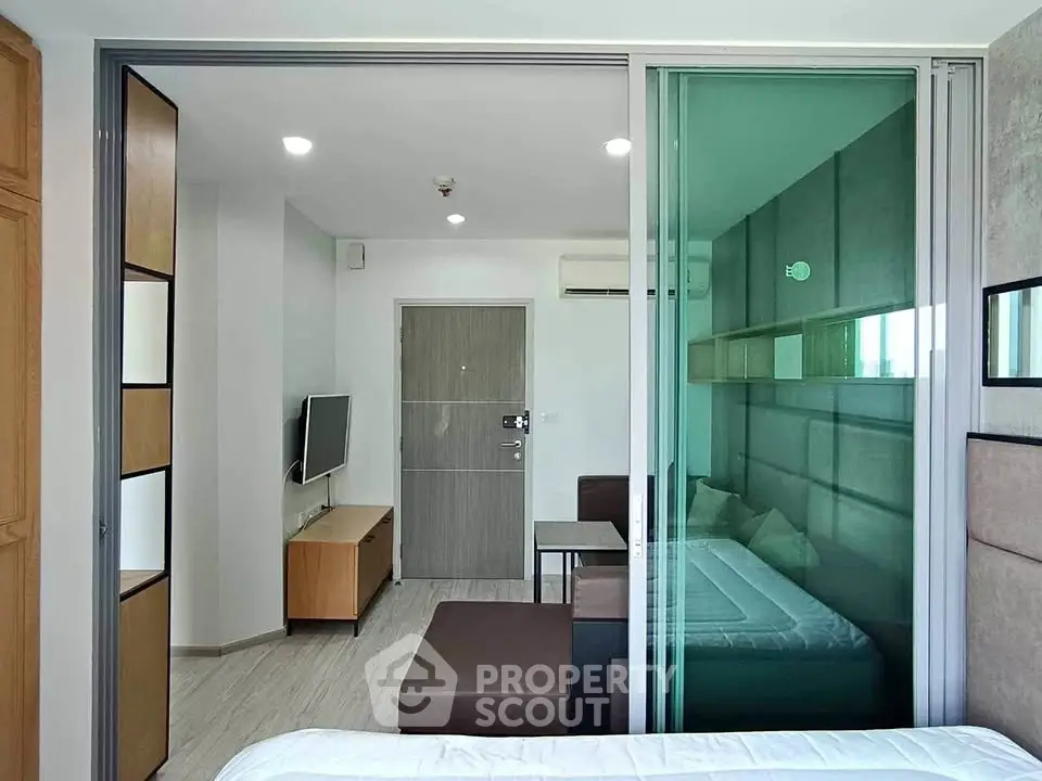 Modern studio apartment with sliding glass partition and stylish furnishings