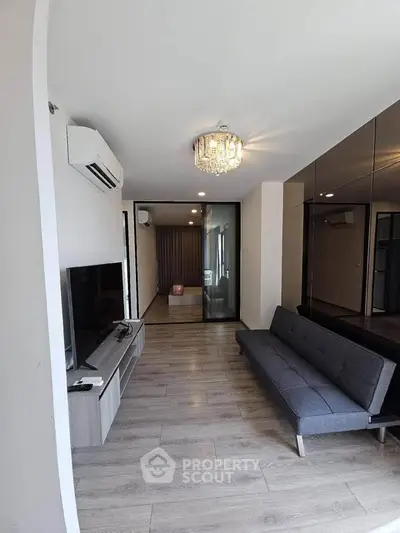 Modern living room with sleek design, featuring a stylish sofa, TV unit, and elegant lighting.