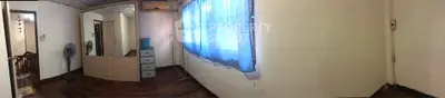 Spacious room with wooden flooring and large window with blue curtains, perfect for customization.