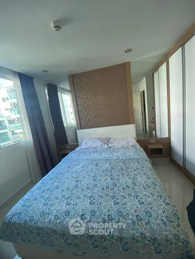 Cozy bedroom with modern decor and large windows offering natural light