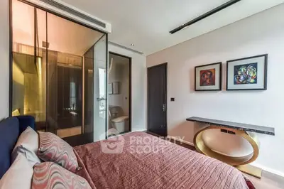 Modern bedroom with stylish decor and glass-enclosed bathroom