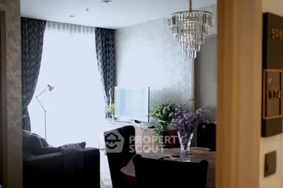 Elegant living room with chandelier, large window, and modern decor