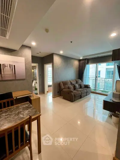 Spacious living room with modern decor and balcony access in a stylish apartment.