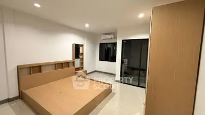 Spacious modern bedroom with minimalist design and ample natural light.