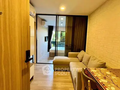 Cozy living room with large sofa and glass partition leading to bedroom